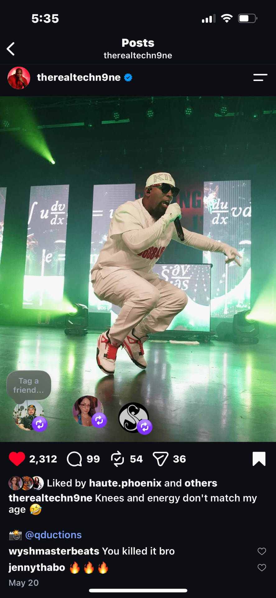 Tech N9ne performing on stage in all white outfit