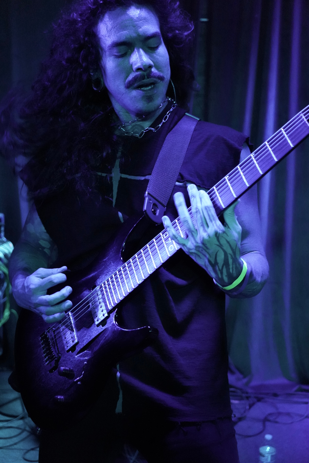 Guitarist with mustache under deep blue light