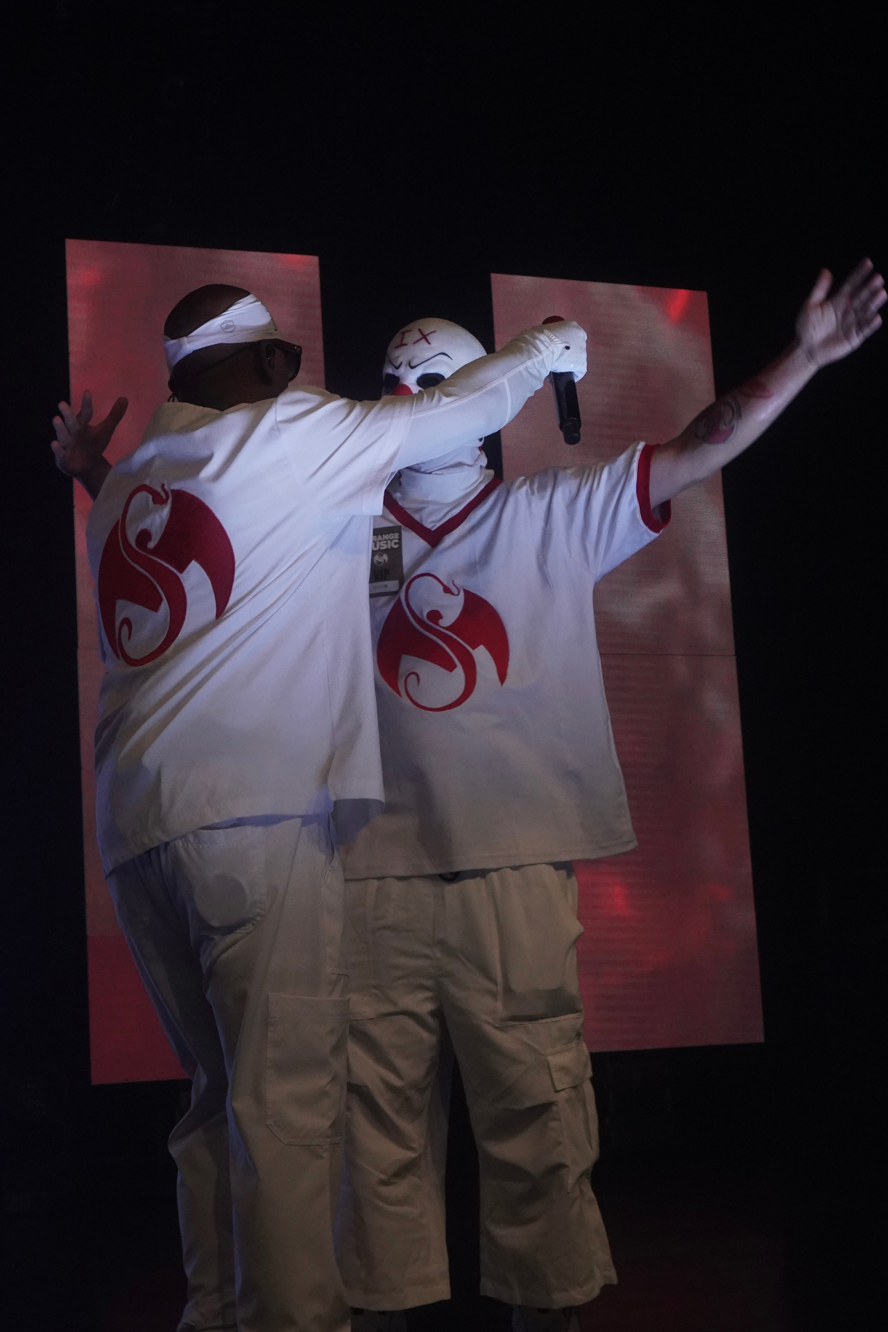 Tech N9ne and Krizz Kaliko embracing with arms raised on stage