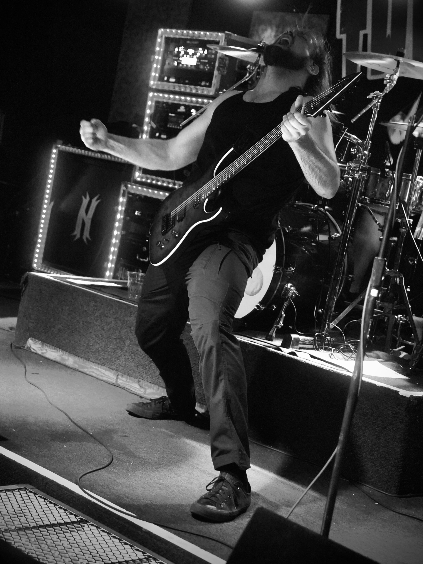 Guitarist shredding on stage in black and white