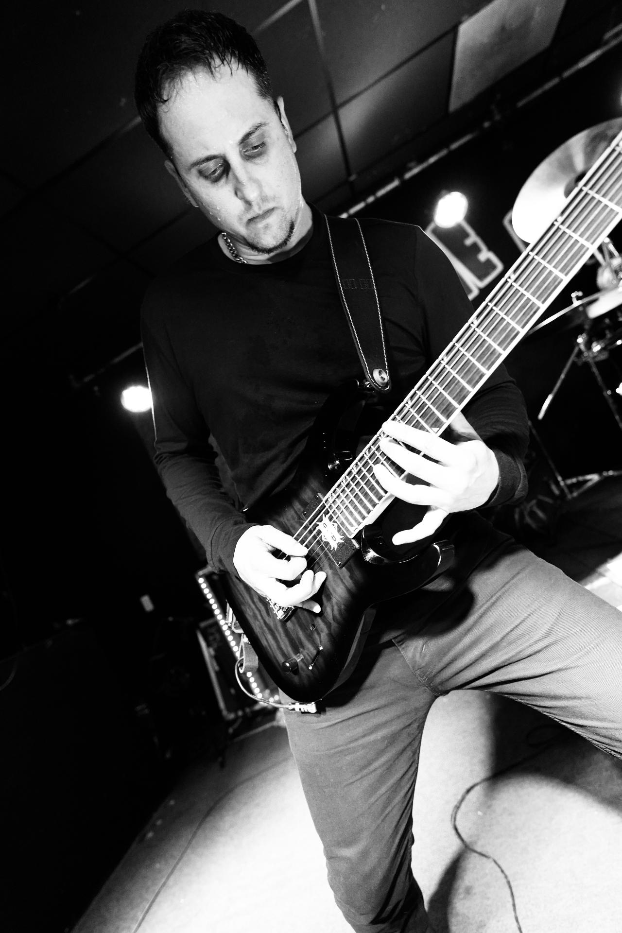 Guitarist mid-solo on a seven-string in black and white