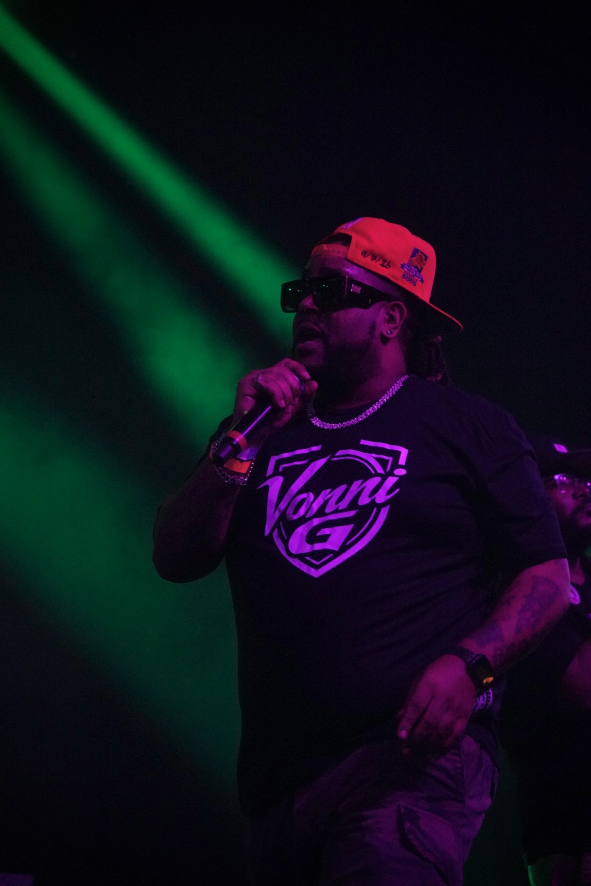 Rapper performing under green and purple lights
