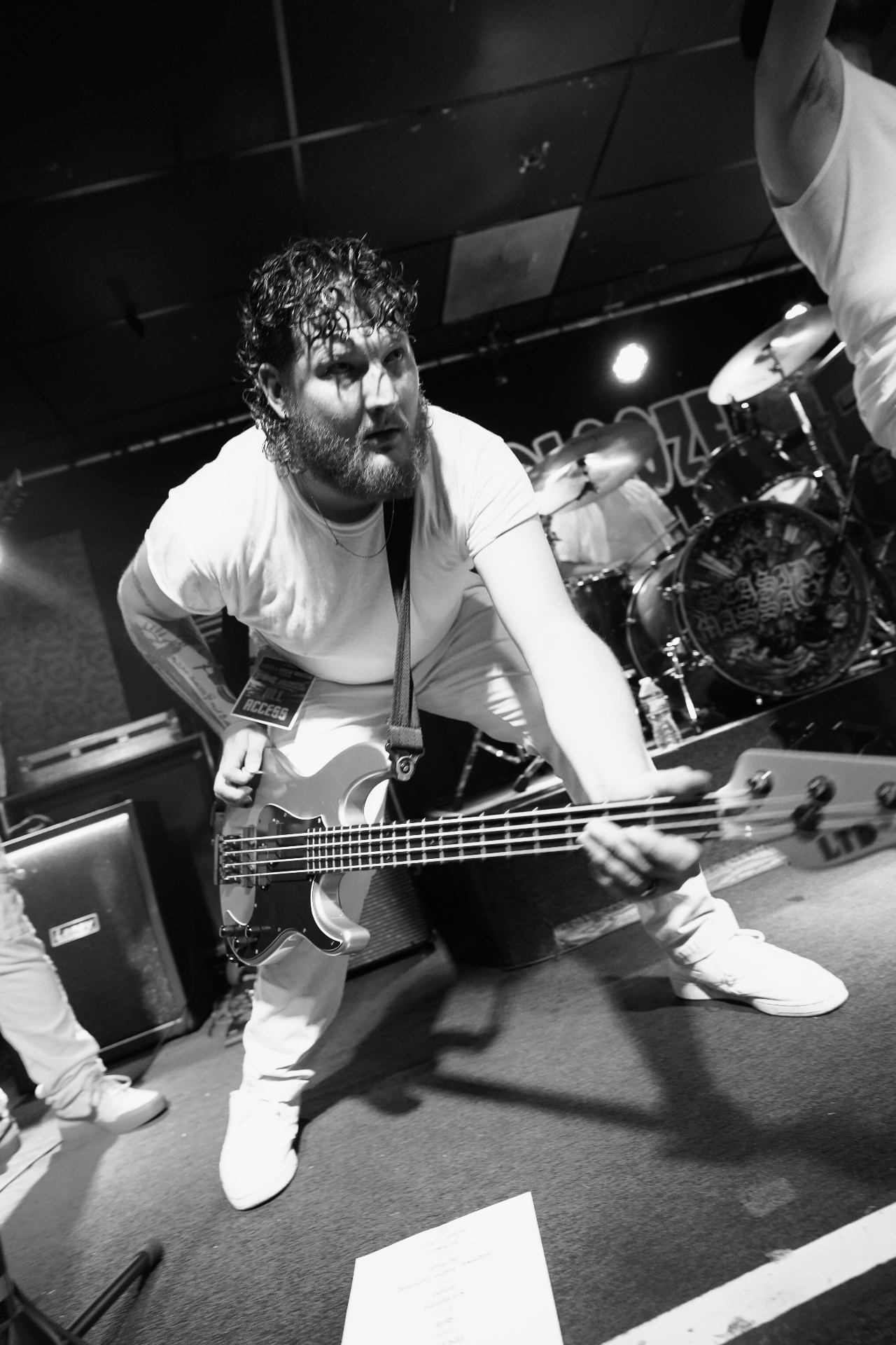 Bassist gripping bass on stage in black and white