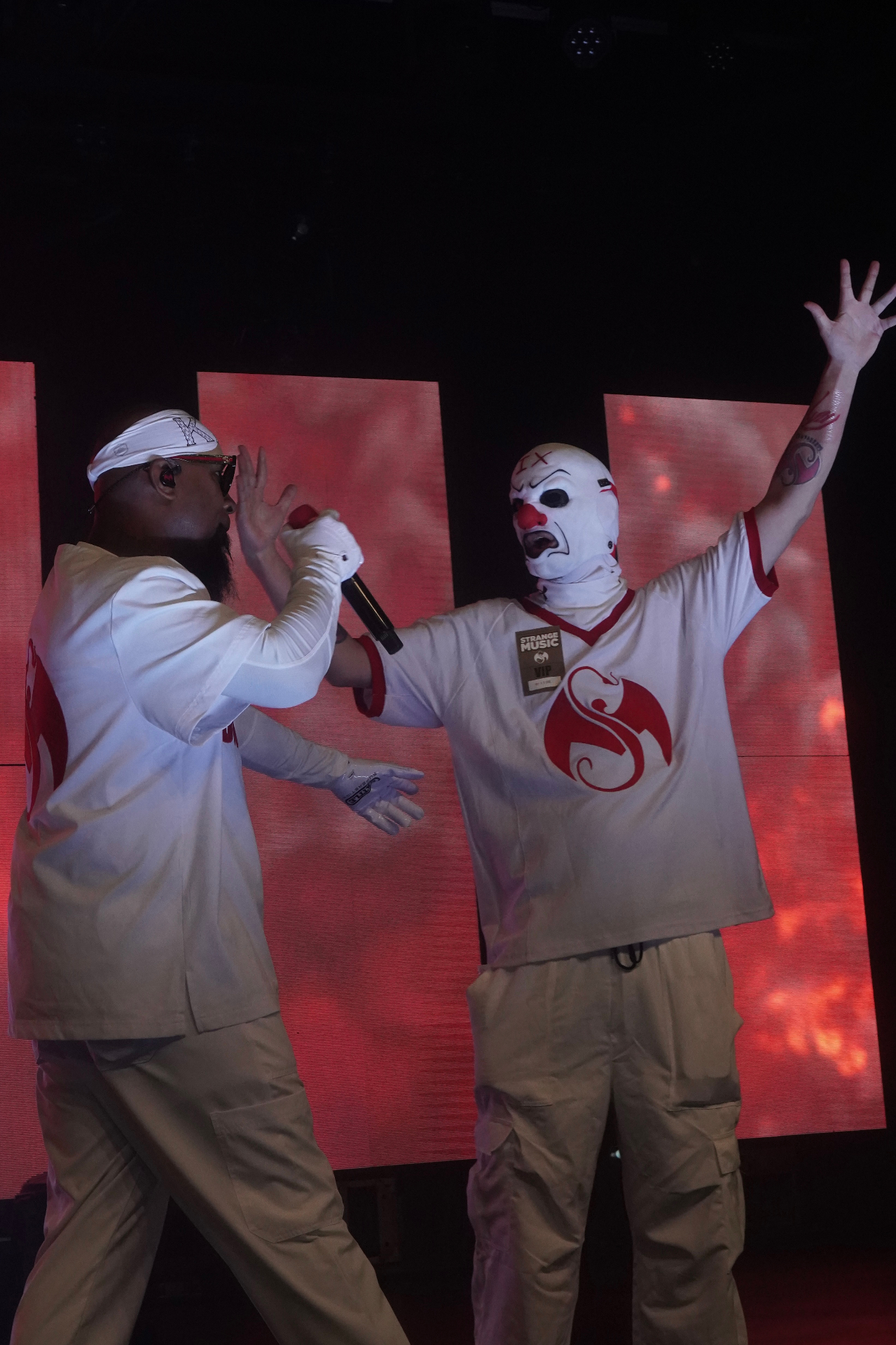 Tech N9ne performing on stage with red backdrop