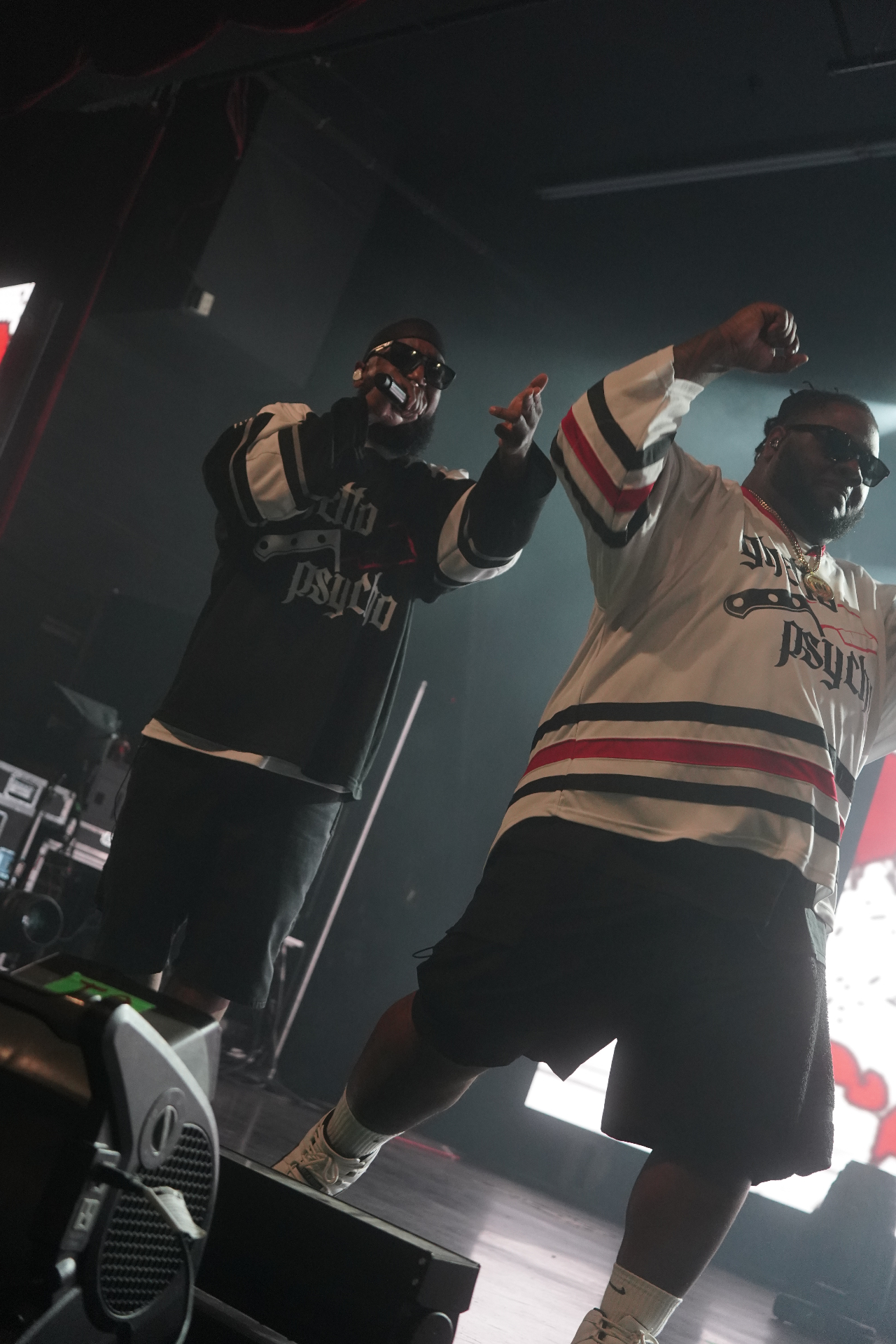 Two artists in Ghetto Psycho jerseys pointing to the crowd