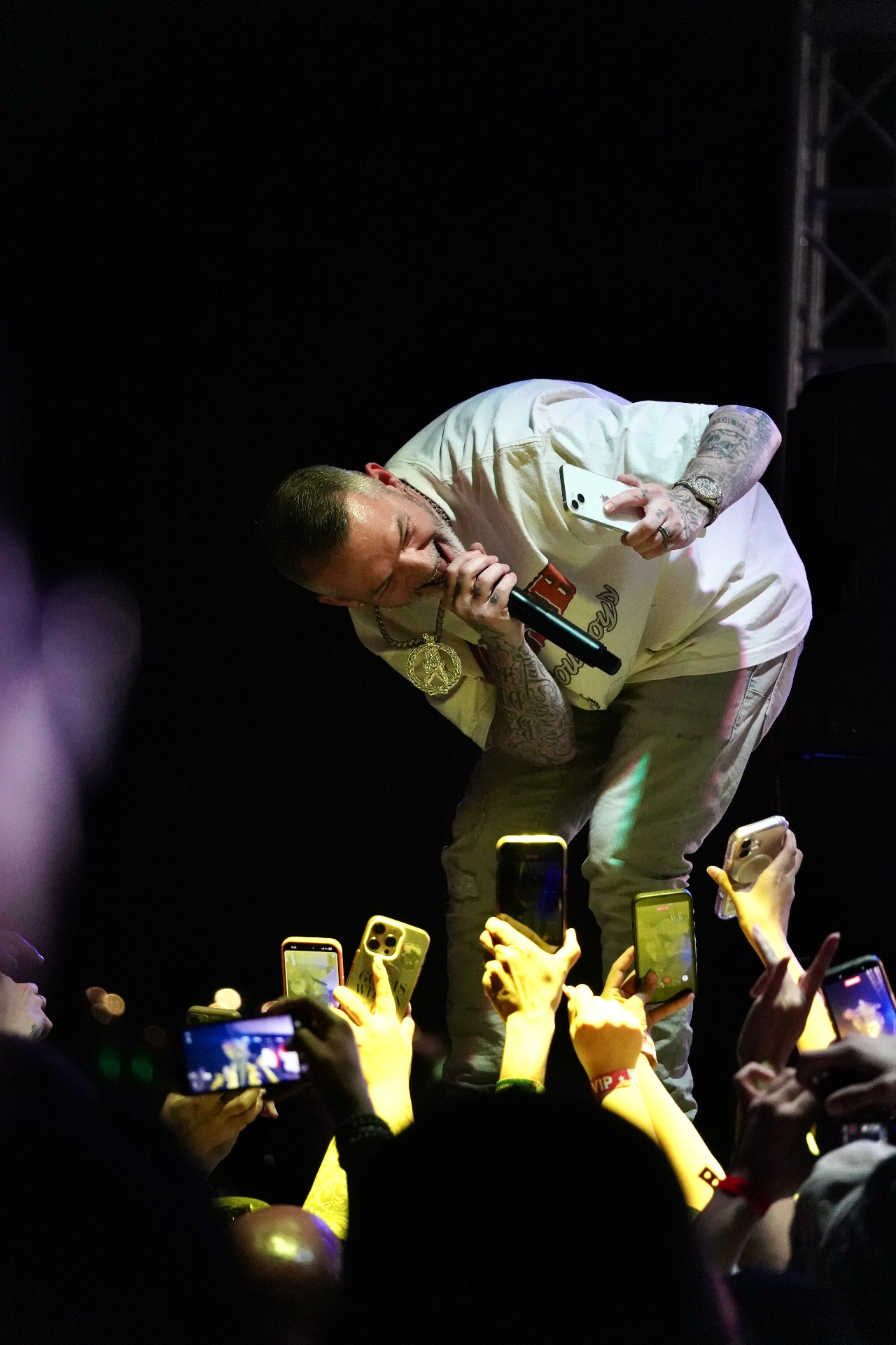 Rapper leaning into the crowd with mic