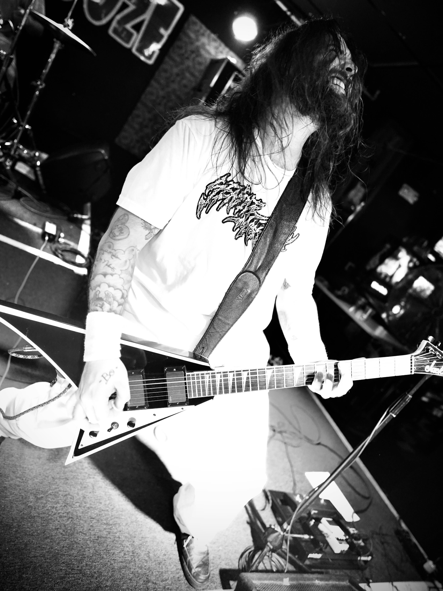 Metal guitarist with Flying V mid-headbang in black and white